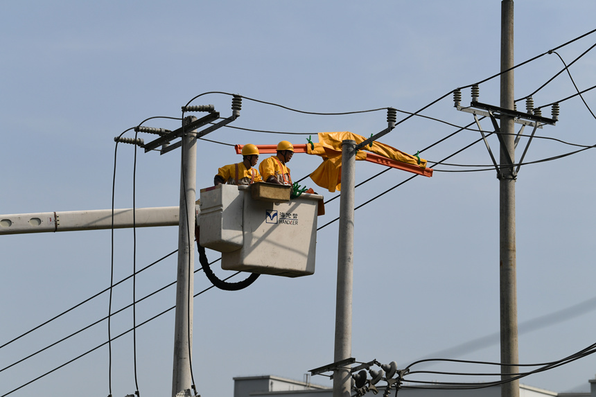 電力公司工作人員在巴南區(qū)界石鎮(zhèn)虎嘯村開展帶電作業(yè)。潘洪攝