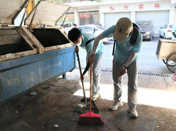 實踐團成員在一品街道清掃街道。重慶財經(jīng)學(xué)院供圖