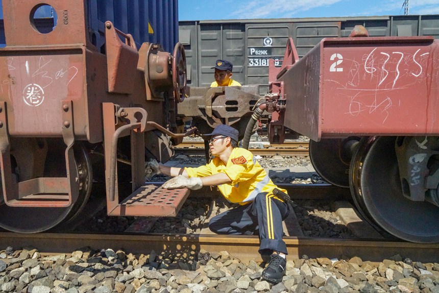 8月9日，重慶西車輛段貨車檢車員正在進行檢查中歐班列鉤緩連接部技術狀態(tài)。劉彪攝