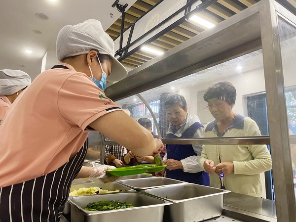 老年居民在社區(qū)食堂吃飯。唐鑫 攝