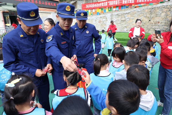 消防員給小朋友發(fā)放禮品。彭水縣消防救援大隊供圖