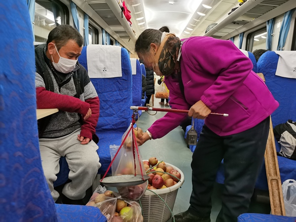 乘客在列車上購買蘋果。張章攝