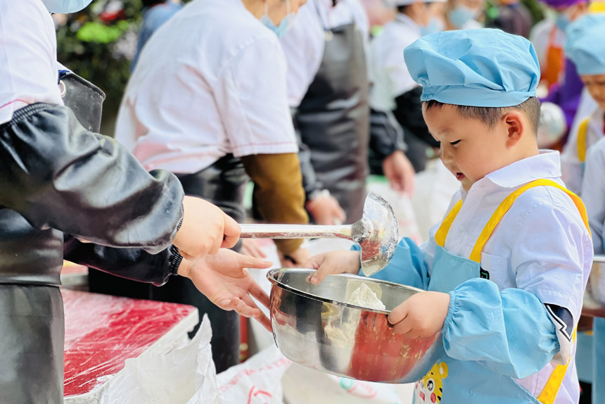 幼兒園小朋友排隊領(lǐng)面粉。晏玉雪攝