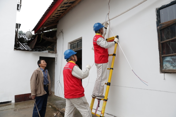 工作人員在歇馬街道虎頭村為村民更換老舊電線。張強(qiáng)攝