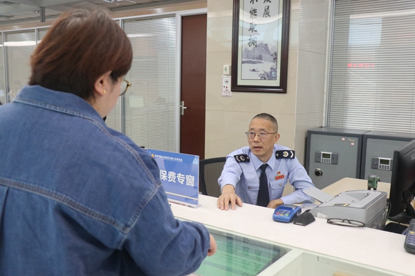 綦江區(qū)稅務局黨委書記、局長曾亞鋒在社保繳費專窗為市民辦理業(yè)務。李奕萱攝