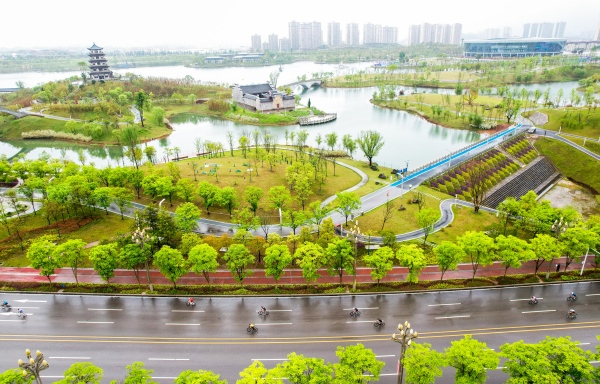 選手騎行在美麗的三合湖公園賽道上 。龔長(zhǎng)浩攝