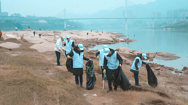 組織員工沿江岸撿拾垃圾。浦發(fā)銀行重慶分行供圖